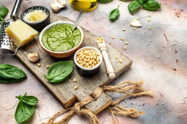 İçinde fesleğen, zeytinyağı, parmesan, sarımsak, çam fıstığı olan pesto sosu. afiş, menü, metin için tarif yeri, üst görünüm.