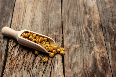 Ahşap masa arkasında kavrulmuş baharatlı nohut. afiş, menü, metin için tarif yeri, üst görünüm,