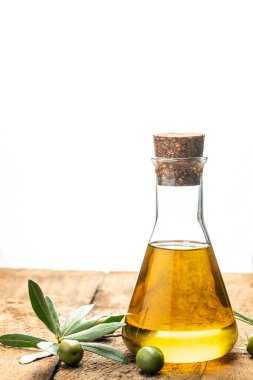 Siyah ve yeşil zeytinli ve yapraklı şişelerde zeytin yağı. Ahşap arka planda ekstra saf zeytinyağı kavanozları. dikey görüntü. Üst Manzara. metin için yer.