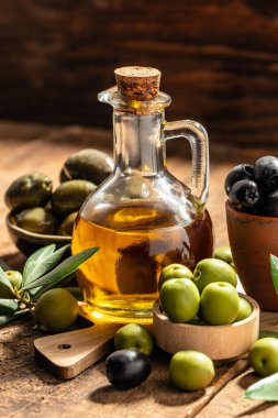 Ahşap arka planda cam şişelerde ekstra saf zeytinyağı. Sağlıklı ve detoks gıda konsepti. metin için yer.