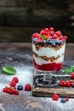 Yoğurtlu granola parfe yaban mersini ve ahududu. dikey görüntü. Üst Manzara. metin için yer.