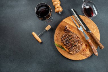 Biftek ve kırmızı şarap. Ahşap kesme tahtasında ızgara et. afiş, menü, metin için tarif yeri, üst görünüm.