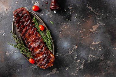 Koyu bir arka planda kızgın pirzola kesme tahtası. Barbekü soslu Amerikan pirzolası. Restoran menüsü, diyet, yemek kitabı tarifi üst görünümü.