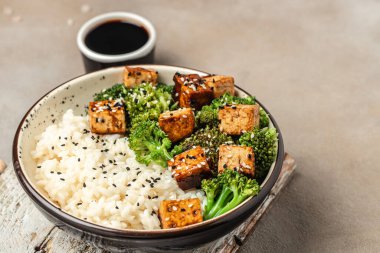 Baharatlı sotelenmiş Çin pirinci, kızarmış tofulu brokoli, Asya vegan kasesi, uzun pankart formatı. en üstteki görünüm,
