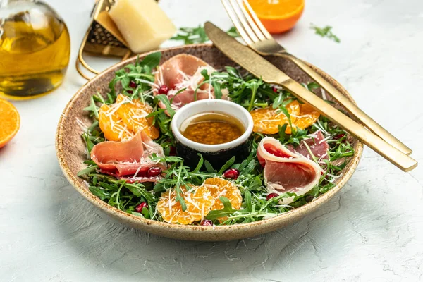 stock image winter salad with arugula mandarins, prosciutto jamon and Parmesan cheese. place for text, top view.