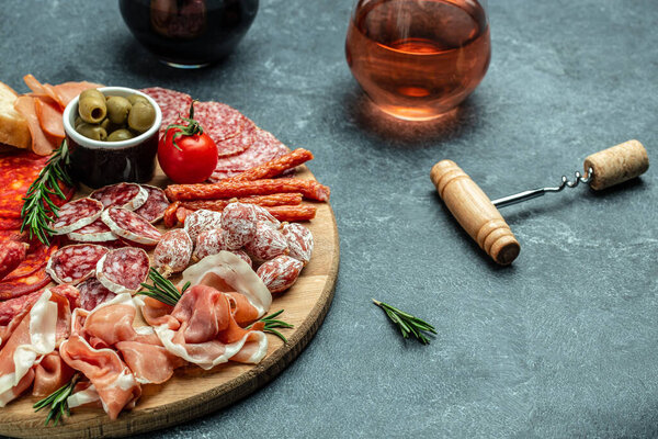 Meat platter appetizers. dry sausages set on a dark background. Long banner format. top view.