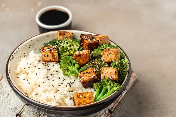 Savory sauteed mixed chinese rice, broccoli with fried tofu, Asian vegan bowl, Long banner format. top view,