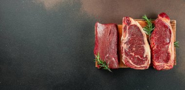 Siyah angus bifteği çeşitliliğini koyu arka planda tut. Biftekçi tipler. Uzun afiş biçimi. en üstteki görünüm