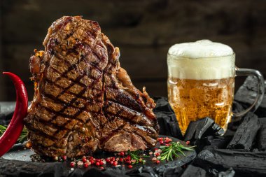 Izgara et ve bir kupa bira. T-bone ya da biftek bifteği. Restoran menüsü, yemek kitabı tarifi üst görünümü.