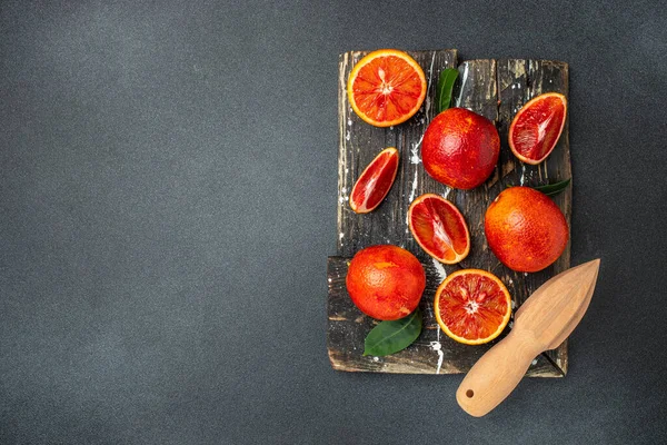 红色的橙子和叶子在黑色的背景 食谱的位置 顶部视图 — 图库照片