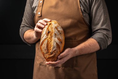 Erkek eli ekmek tutuyor. evcilleştirilmiş fırın pastası. Sağlıklı gıda konsepti. metin için yer.