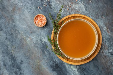 Bone meat chicken broth in a bowl on a dark background, banner, menu, recipe place for text, top view.