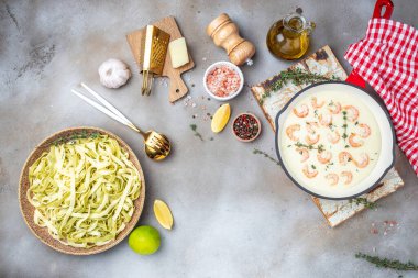 shrimps bechamel sauce in pan. pasta on a dark background. banner, menu, recipe place for text, top view.