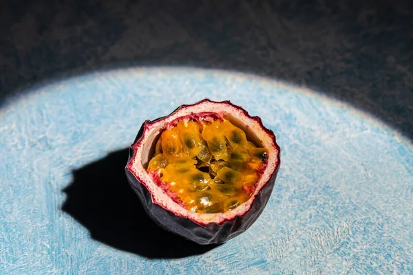 Purple passion fruit with cut in half on a blue background, Long banner format. top view.