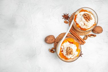 Hafif arka planda katmanlı balkabağı ve krem peynirli tatlı. afiş, menü, metin için tarif yeri, üst görünüm.