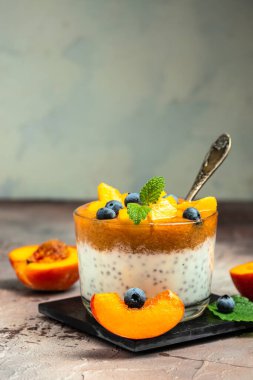 homemade dessert with fruits, parfait yogurt with peaches blueberry and chia. place for text.
