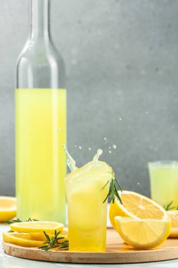 Bir bardak limoncello geleneksel İtalyan alkollü içeceği. Donmuş hareket sıçrama sıvısı damlaları. dikey görüntü. metin için yer.