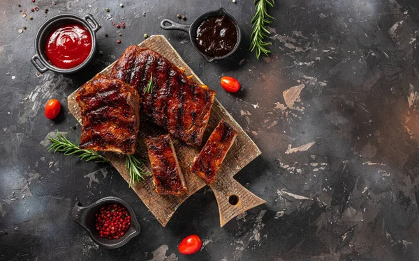 Spicy rack of spare ribs with marinade on a wooden board, banner, menu, recipe place for text, top view.