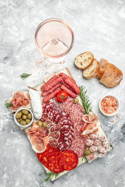 Et tabağı. Prosciutto, pastırma, salam ve sosis ile ahşap kesme tahtası. İtalyan aperatifleri ya da arka planda hafif bir antipasto. en üstteki görünüm.