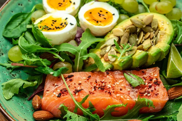 stock image Salmon fillet with fresh salad, grape, eggs and avocado. set of healthy food for keto diet.