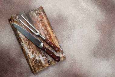 Beton zeminde et bıçağı ve barbekü çatalı. Biftek ızgara için malzemeler. Uzun afiş biçimi. en üstteki görünüm.