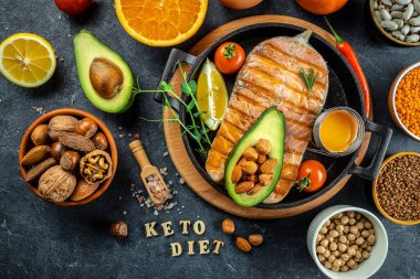 Avokado ve taze sebze salatasıyla ızgara somon bifteği. Keto diyet konsepti sağlıklı yiyecekler, sağlıklı yağlar, kilo vermek için temiz yiyecekler. en üstteki görünüm.