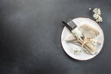 Beyaz çiçeklerle dolu bir masa. Karanlık bir arka planda bayram yemeği için şenlik masası. metin için yer, üst görünüm.