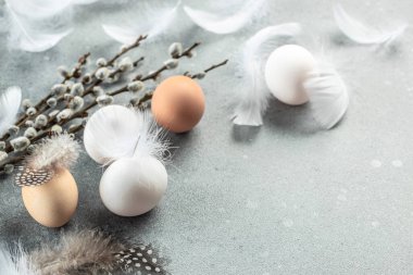Açık gri arka planda yumurta ve çiçekli Paskalya sofrası. Mutlu Paskalya tatili konsepti. metin için yer, üst görünüm.
