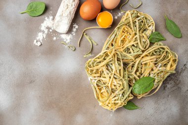 Taze makarna ve malzemeler. yeşil ve sarı makarna tagliatelle. afiş, menü, metin için tarif yeri, üst görünüm.