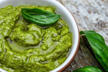 bowl with green pesto pine nuts, parmesan and garlic. Food recipe background. Close up.