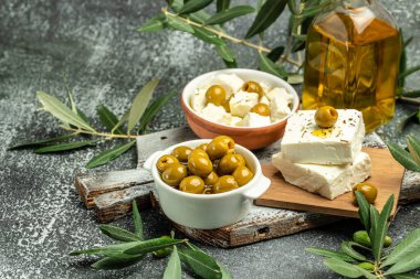 Fettan peynirli yeşil zeytin ve koyu arkaplanda taze zeytin dalı. Üst Manzara. metin için yer.