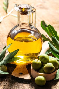Zeytin ve yağ. Ahşap arka planda ekstra saf zeytinyağı kavanozları. dikey görüntü. metin için yer.
