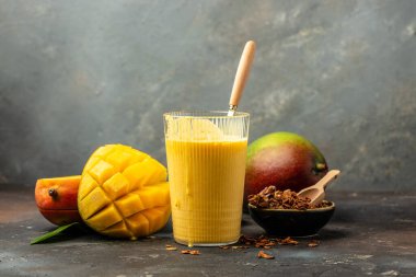 Mango Lassi, yoğurt ya da zerdeçal ile smoothie. Karanlık bir arka planda taze tropikal meyve. Uzun pankart biçimi.