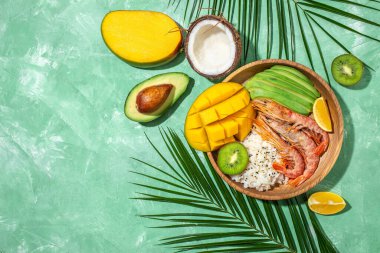 Avokado, karides, pilav, mango, kivi ve hindistan cevizli dürtme kasesi, sağlıklı ve dengeli yemek. afiş, metin için menü tarifi yeri, üst görünüm