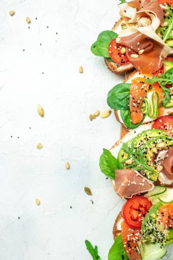 Krem peynirli sandviç seti, prosciutto, somon, avokado ve taze yeşillik. Keto, ketojenik diyet, düşük karbonhidrat, yüksek yağ, sağlıklı yiyecekler. en üstteki görünüm.