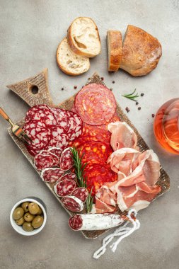 Salami, sliced ham, sausage, prosciutto bacon. Meat antipasto platter wirh wine. Food recipe background. Close up.