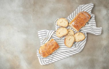 İtalyan ciabatta ekmeği, arka planda dilimler halinde kesilmiş. afiş, menü, metin için tarif yeri, üst görünüm.