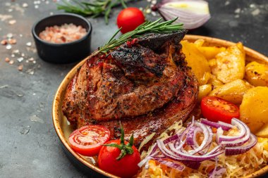 roasted pork leg with fried potatoes, Food recipe background. Close up,