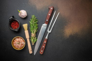 Eski mutfak gereçleri: Et Çatalı ve Kasap Satırı ve Bıçak, koyu bir arka planda ızgara et bifteği için malzemeler. metin için yer, üst görünüm,