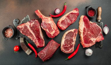 Çiğ Black Angus Prime bifteği T-bone, tomahawk, New York bifteği çeşitleri. Çiğ mermer sığır filetosu bifteği koyun. metin için yer, üst görünüm.
