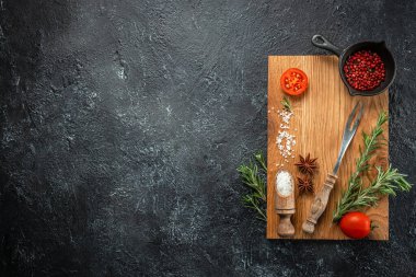 Kesme tahtası, baharatlar ve arka planda biberiye. Yemek pişirme. metin için yer, üst görünüm.