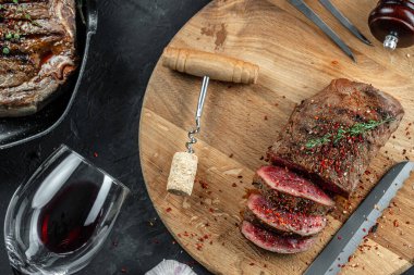 Biftek ve kırmızı şarap. Ahşap kesme tahtasında ızgara et. afiş, menü, metin için tarif yeri, üst görünüm.