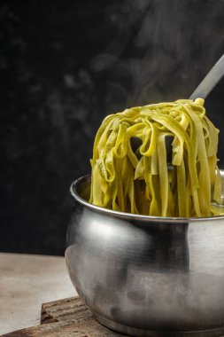 fettuccine pasta in pan cooking in boiling. vertical image. top view. place for text.