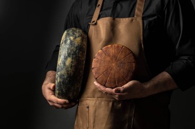 cheesemaker mele hands holding wheel hard cheese,