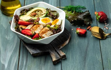 Keto kahvaltısı iki yumurta, avokado, çilek, ızgara tavuk fileto, fındık ve taze salata, ketogenik diyet. Keto diyet yemekli tabak. Sağlıklı gıda konsepti, üst görünüm.