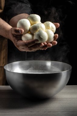 Elinde mozarella tutan bir adam. İtalyan sert peyniri silano veya caciocavallo, mozzarella.