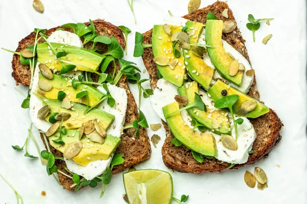 avocado toasts with cheese, pumpkin, nut and sesame. Healthy fats, clean eating for weight loss.
