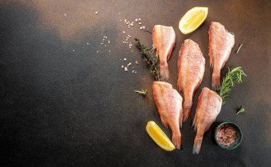 Limonlu çiğ balık levreği, biberiye, koyu arkaplanda tuz. afiş, menü, metin için tarif yeri, üst görünüm.