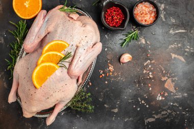 fresh whole raw duck with orange thyme and spices, prepare to cook, banner, menu, recipe place for text, top view,