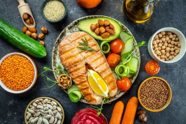 Avokado ve taze sebze salatasıyla ızgara somon bifteği. Keto diyet konsepti sağlıklı yiyecekler, sağlıklı yağlar, kilo vermek için temiz yiyecekler. en üstteki görünüm.